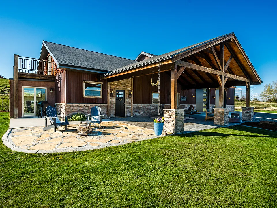 A custom barndominium with stone accents and covered patio, built by Greenhouse Construction near Sheridan, Wyoming